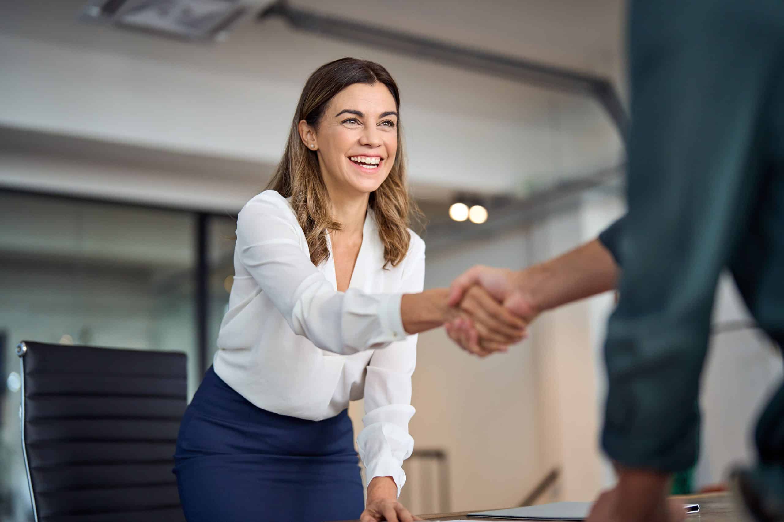 A confident female CFO in a business suit, standing in a modern office, representing leadership and success in the finance industry.